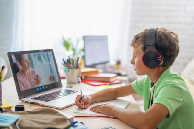 boy with headphones learning from virtual tutor